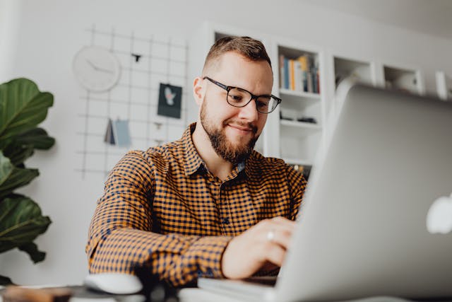 A tenant using his laptop, smiling