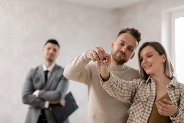 pexels-a-darmel-7641900 Real estate agent proudly watching as tenant couple happily holds the keys