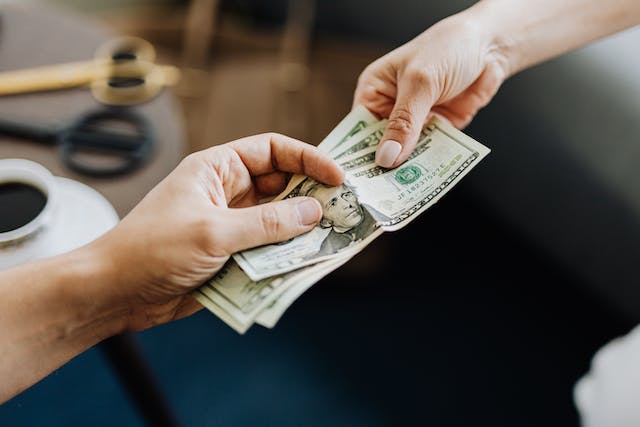 person-handing-over-money-to-another-person-for-their-investment-property person-handing-over-money-to-another-person-for-their-investment-property